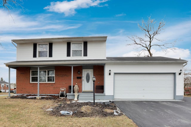 traditional-style house with a garage, brick siding, a porch, and aphalt driveway