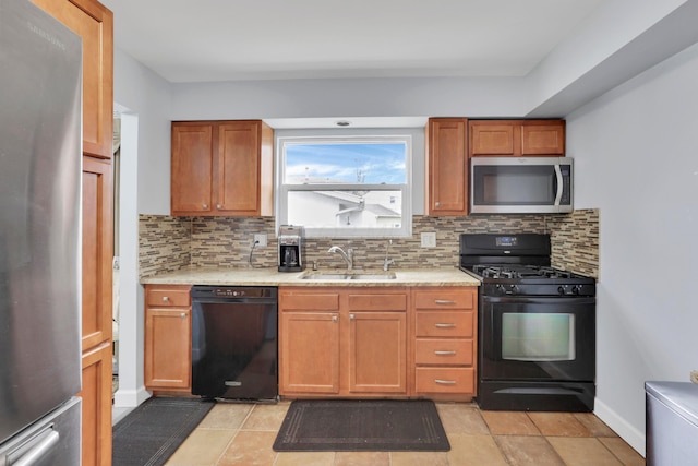 kitchen featuring backsplash, black appliances, baseboards, and a sink