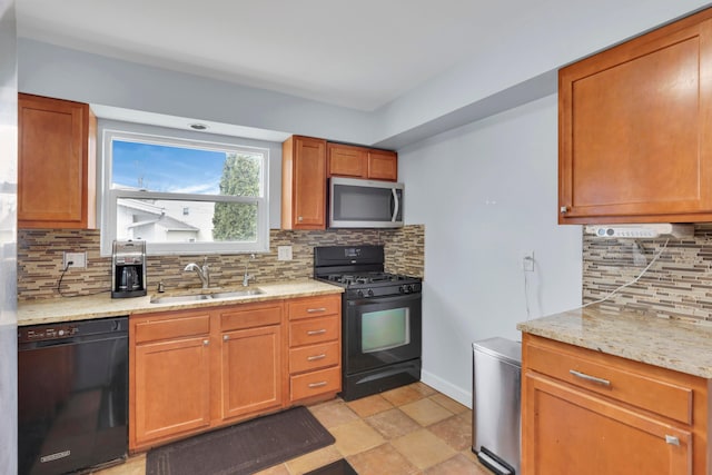 kitchen with black appliances, a sink, backsplash, baseboards, and light stone countertops