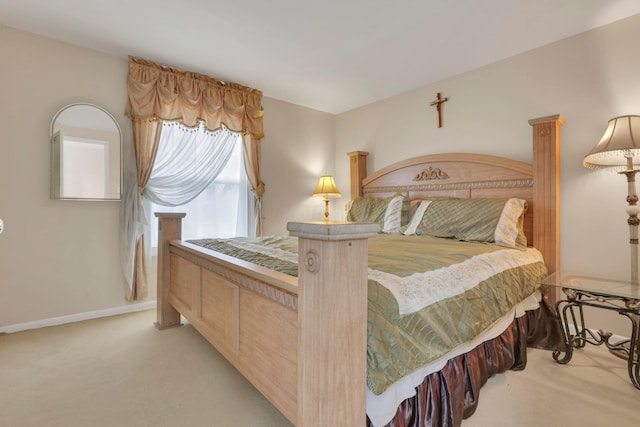 bedroom with light colored carpet and baseboards