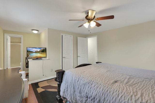 bedroom featuring ceiling fan, baseboards, and dark wood finished floors