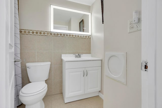 full bath with tile walls, tile patterned floors, toilet, and vanity