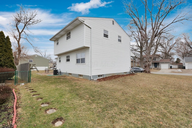 view of home's exterior with cooling unit, a lawn, and fence