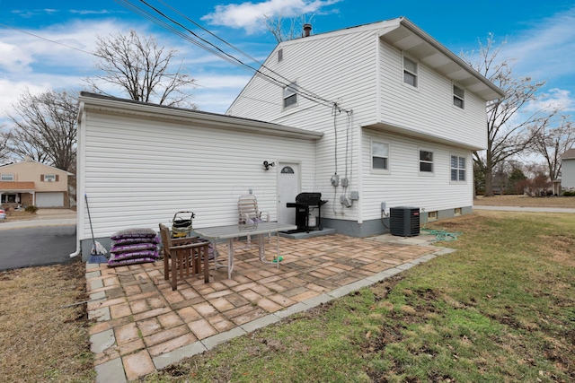 rear view of property featuring a yard, central air condition unit, and a patio