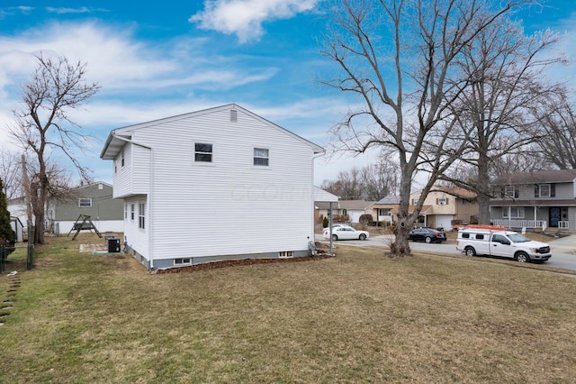 view of side of home with central air condition unit, a residential view, and a lawn