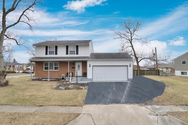 traditional-style home featuring brick siding, driveway, an attached garage, and a front yard