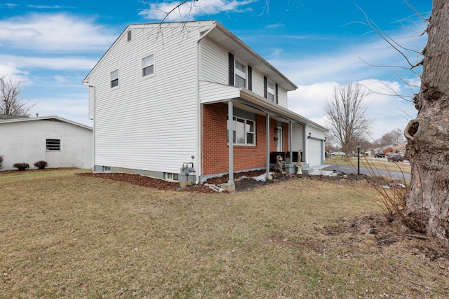 view of side of property featuring brick siding, a garage, and a yard