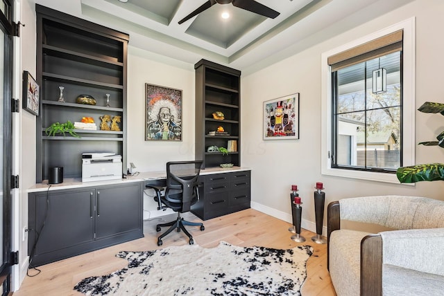 office space featuring beamed ceiling, a ceiling fan, coffered ceiling, light wood finished floors, and baseboards