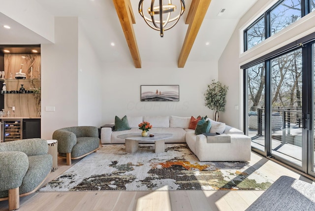 living room featuring an inviting chandelier, beam ceiling, wood finished floors, and beverage cooler