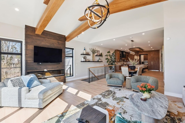 living room featuring beam ceiling, plenty of natural light, a chandelier, and light wood-style floors