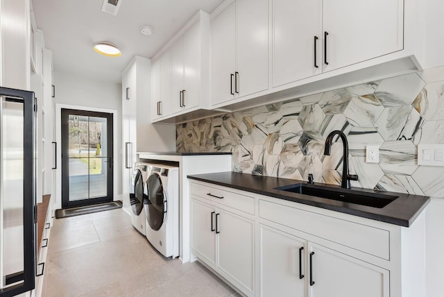 clothes washing area featuring a sink, visible vents, cabinet space, and washing machine and dryer