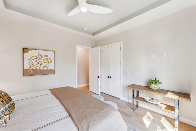 bedroom featuring light wood-style floors, baseboards, and ceiling fan