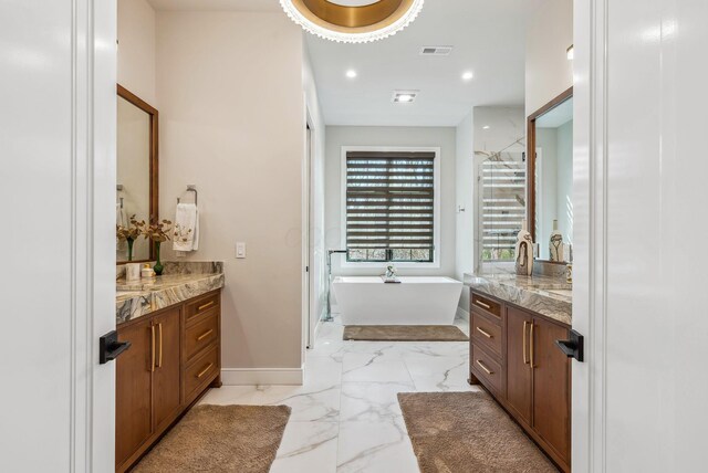 bathroom with visible vents, baseboards, two vanities, a freestanding tub, and marble finish floor