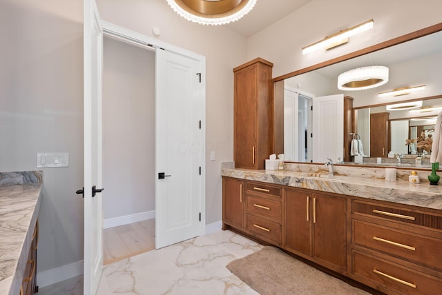 bathroom featuring baseboards, marble finish floor, and vanity