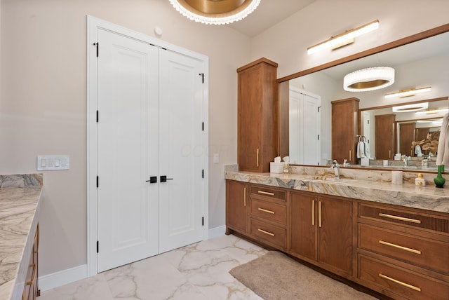 bathroom with a closet, marble finish floor, vanity, and baseboards