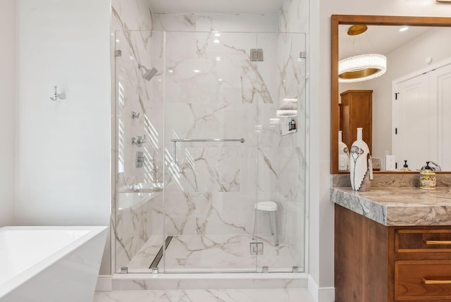 full bath with a freestanding tub, a marble finish shower, and vanity