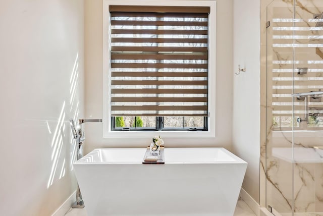 full bathroom featuring a soaking tub and a marble finish shower