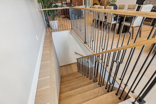 staircase with baseboards and wood finished floors