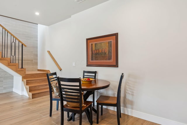 dining area featuring recessed lighting, stairs, light wood-type flooring, and baseboards