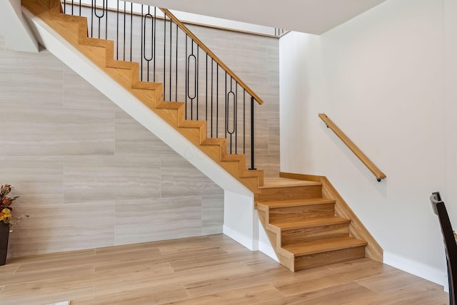 staircase with baseboards and wood finished floors