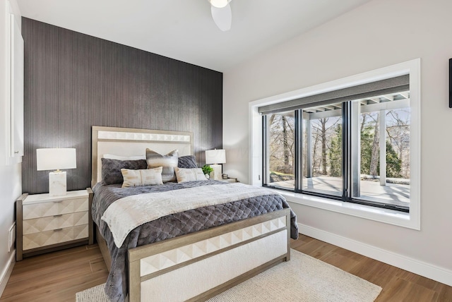 bedroom featuring ceiling fan, baseboards, and wood finished floors