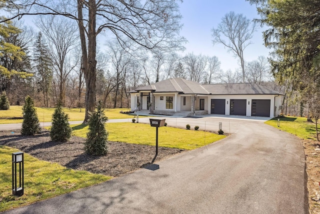 view of front of house with a front lawn, an attached garage, and driveway