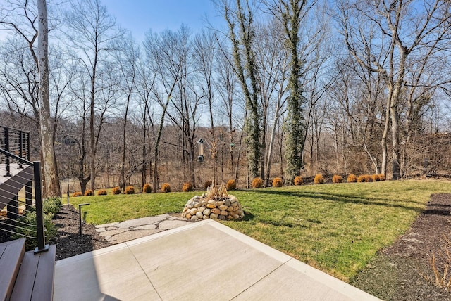 view of yard featuring a patio and a view of trees