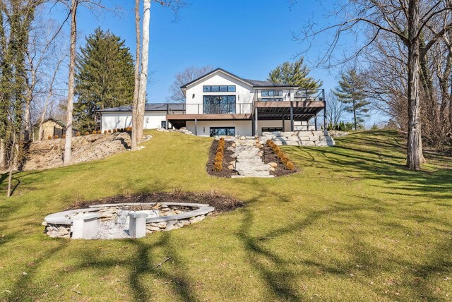 rear view of property featuring a yard, stucco siding, and a deck