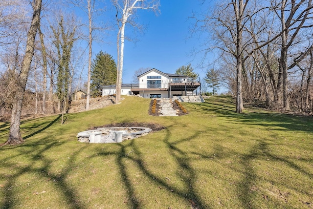 view of yard featuring a deck and an outdoor fire pit