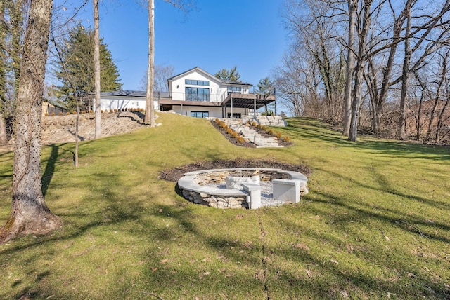 view of yard with stairway, a deck, and an outdoor fire pit