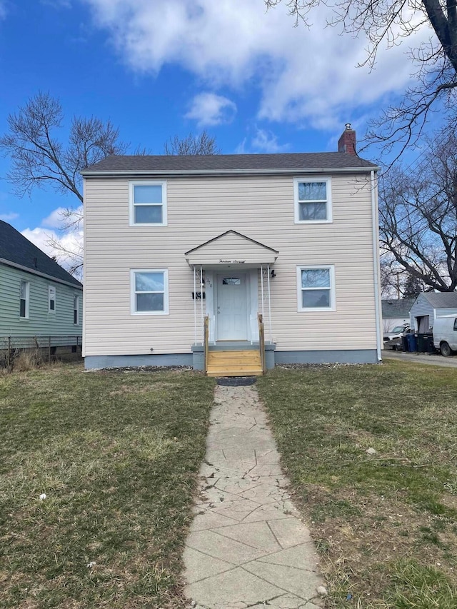 view of front of home with a chimney and a front lawn