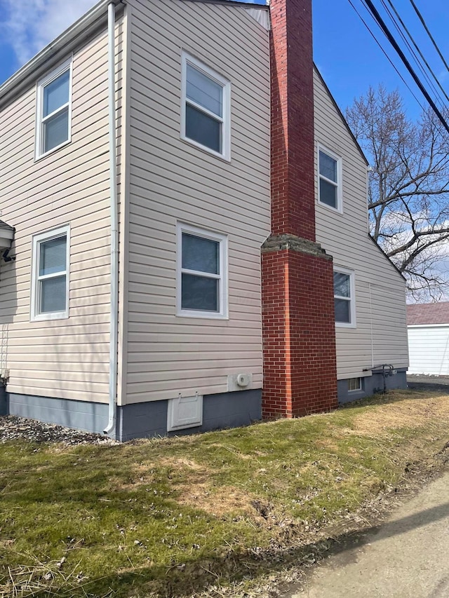 view of home's exterior with a yard and a chimney