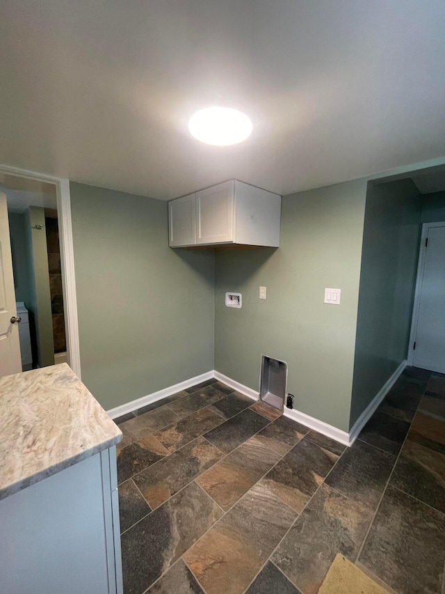 clothes washing area with baseboards, washer hookup, stone tile floors, cabinet space, and hookup for an electric dryer