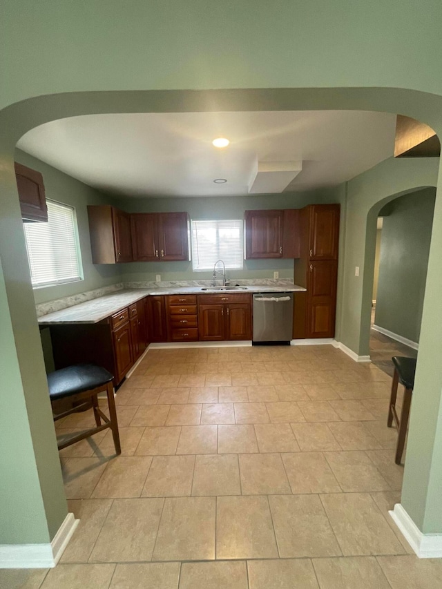 kitchen with a sink, plenty of natural light, dishwasher, and light countertops