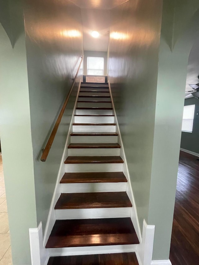 stairs featuring wood finished floors and baseboards