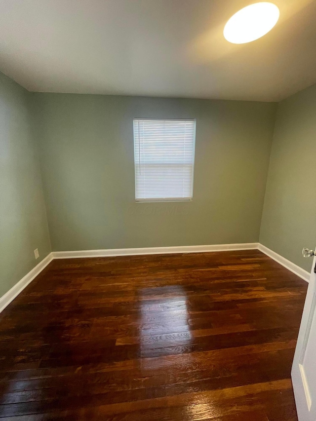 empty room featuring wood finished floors and baseboards