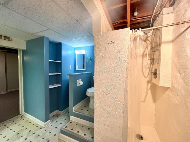 bathroom with tile patterned floors, visible vents, toilet, a drop ceiling, and a shower stall