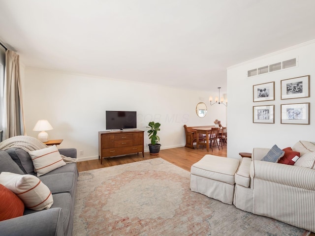 living room featuring wood finished floors, visible vents, and baseboards