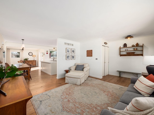 living room with visible vents, baseboards, and wood finished floors