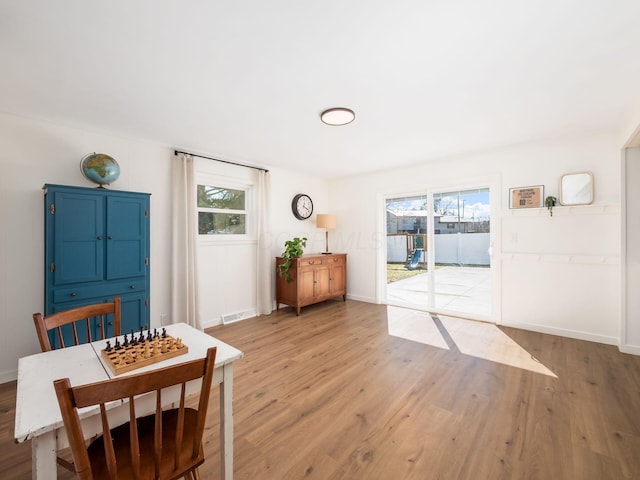 dining space with plenty of natural light, light wood-type flooring, and baseboards