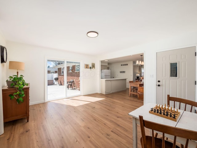 dining area with baseboards and light wood-style floors