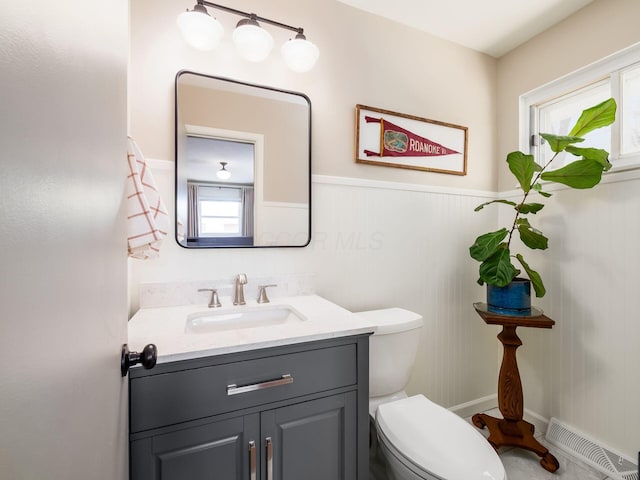 bathroom with vanity, toilet, and visible vents