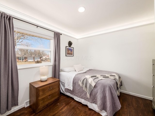 bedroom featuring visible vents, baseboards, and wood finished floors