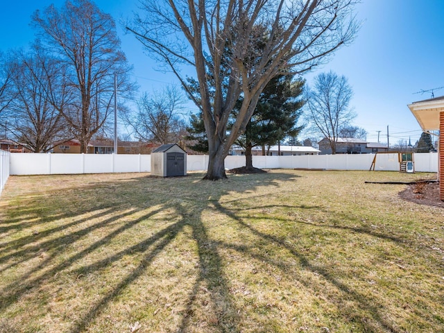 view of yard with an outbuilding, a shed, and a fenced backyard