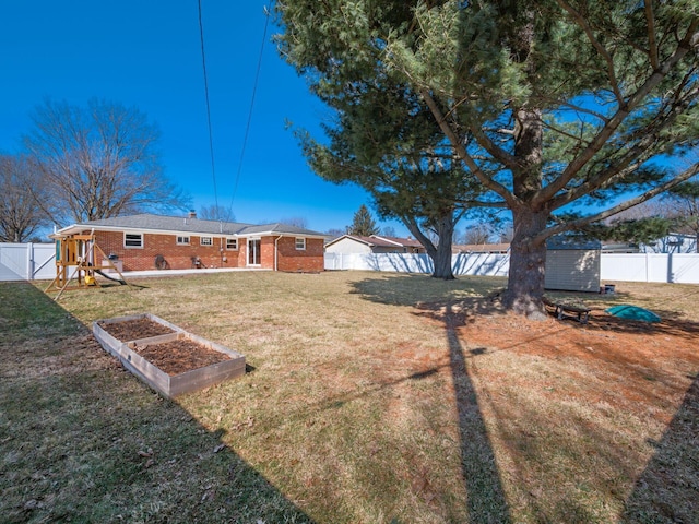 view of yard featuring an outbuilding, a shed, a playground, and a fenced backyard