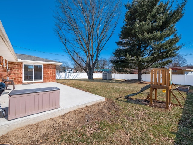 view of yard with an outbuilding, a playground, a patio area, and a fenced backyard