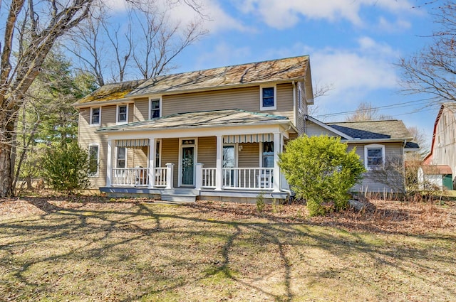 view of front of property with covered porch and a front lawn