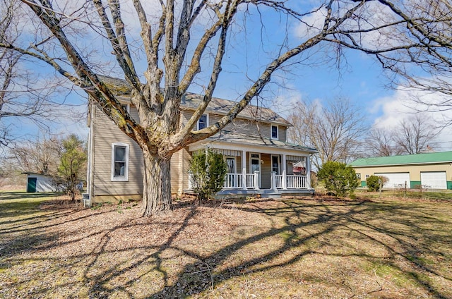 view of front of house with a porch, a garage, and a front yard