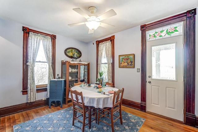 dining space featuring light wood-style floors, baseboards, and ceiling fan