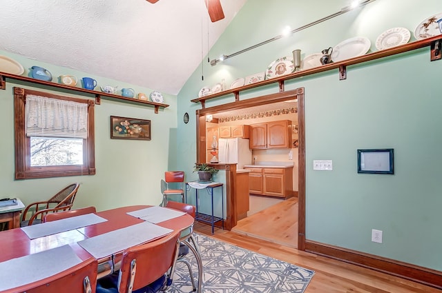 office featuring lofted ceiling, a textured ceiling, ceiling fan, and light wood finished floors